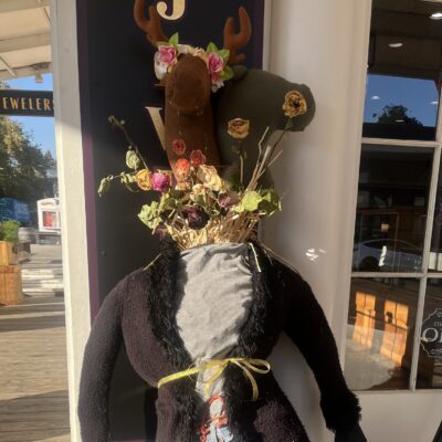 K&S Jewelers scarecrow in a dark coat and a flower-trimmed top hat