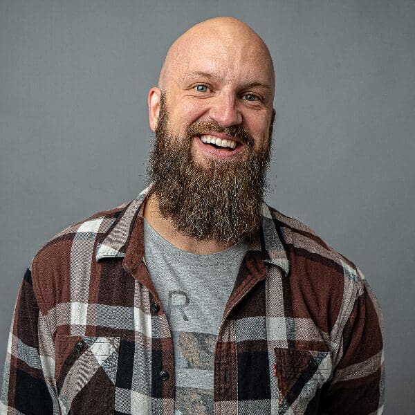 data-111 Comedian Luke Severeid smiling, with a full beard and plaid flannel shirt
