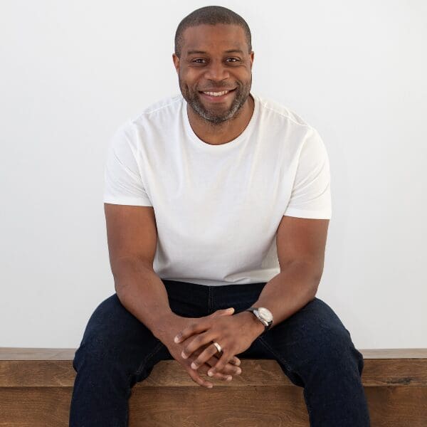 data-21 Comedian Kortney Shane Williams smiling, seated in a white T-shirt