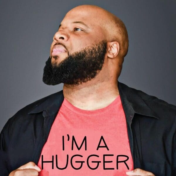 Comedian Mike Paramore looking upward in an "I'm a Hugger" T-shirt